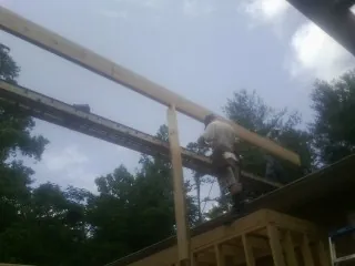 Carpenter setting a ridge beam over a new addition frame — Ice Dam Removal by Roofing Brothers in Lewistown