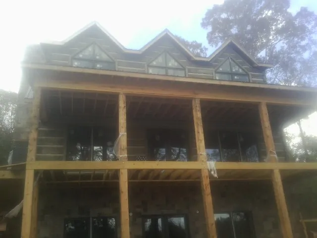Dormers and porch framing on a large log home under construction — Roof Coating work by our crew in Lewistown